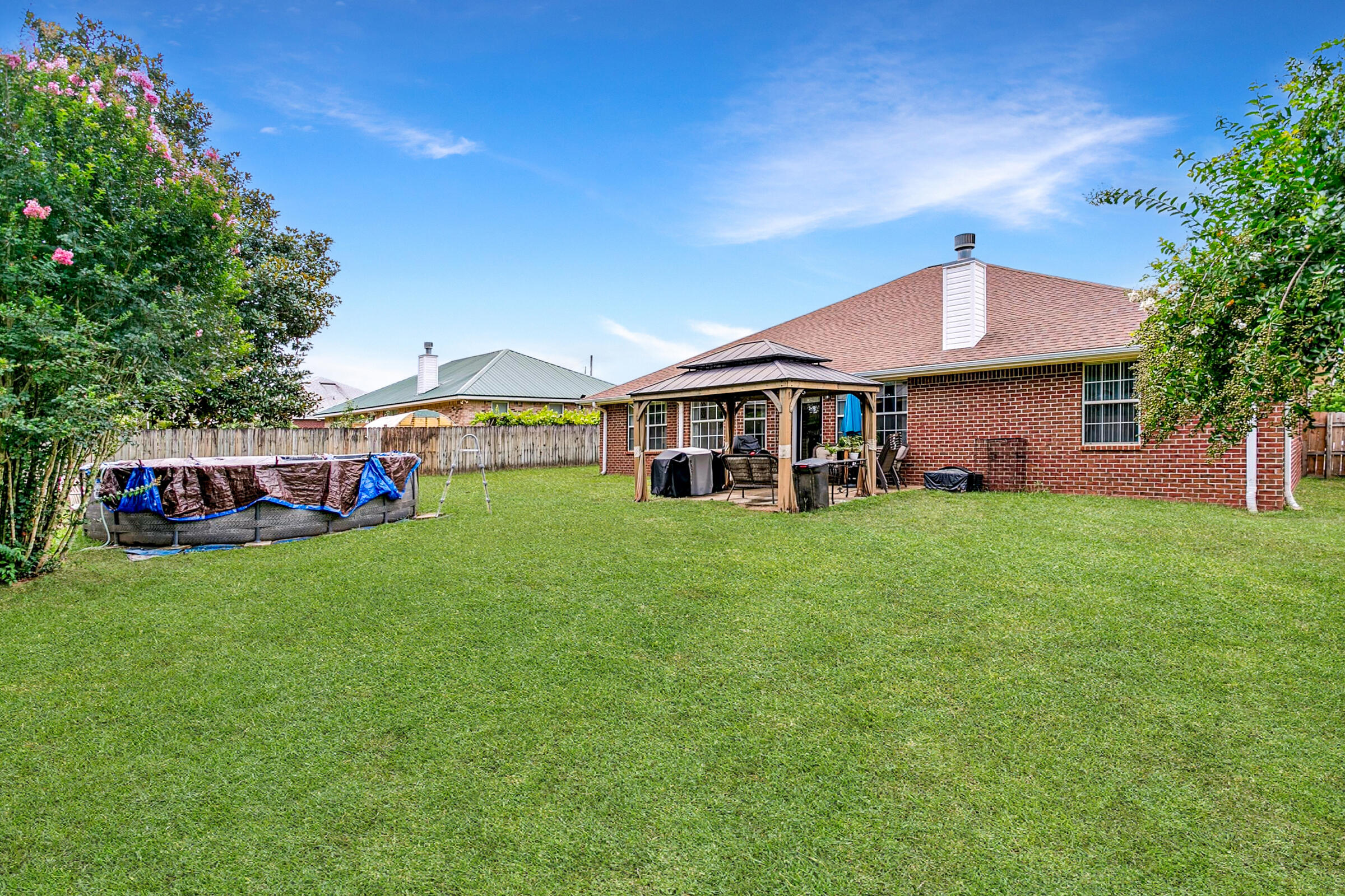 2246 Titanium Drive Crestview, FL 32536 - Photo 25 of 38 a front view of a house with a garden and porch