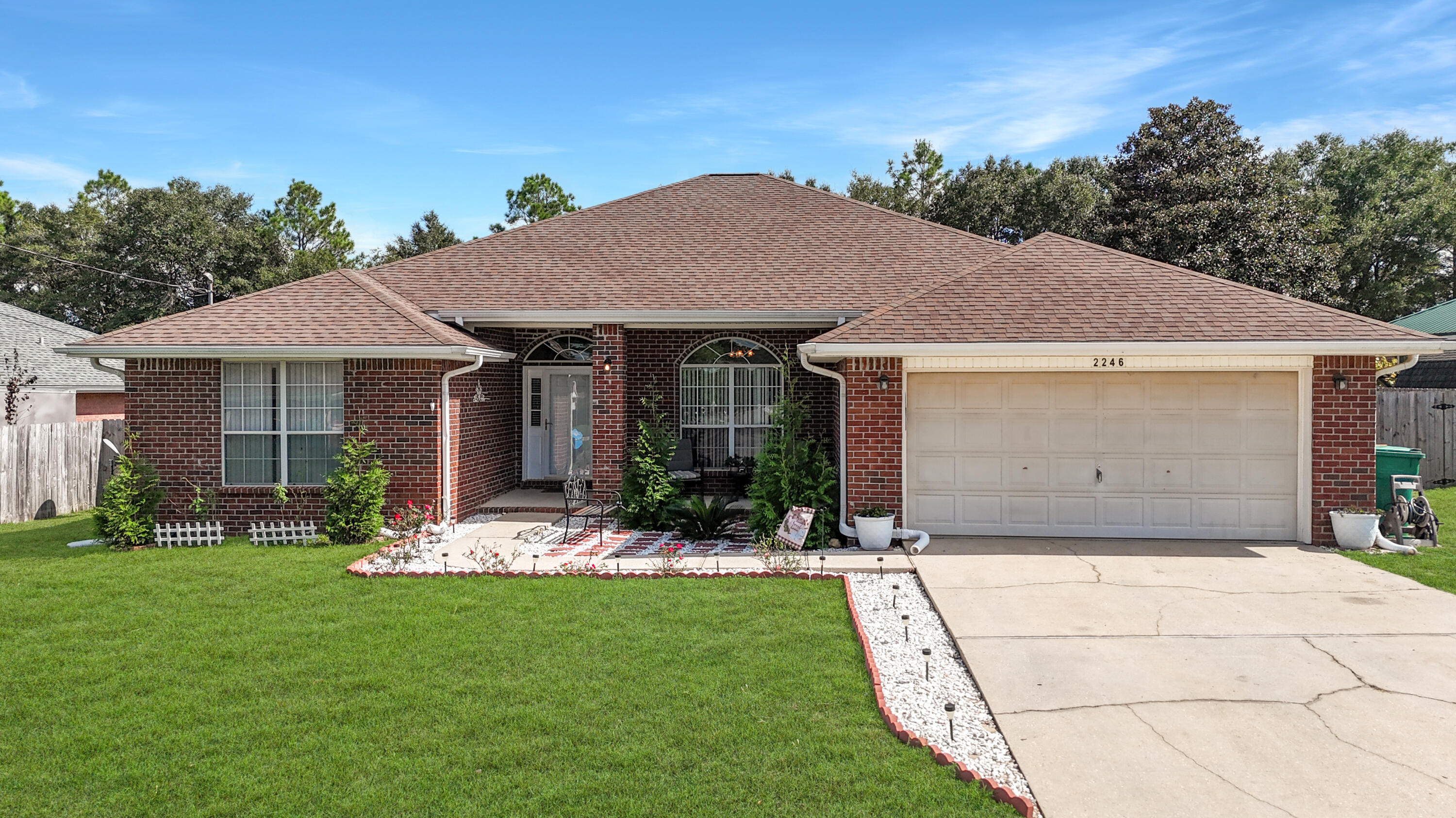 2246 Titanium Drive Crestview, FL 32536 - Photo 34 of 38 a front view of a house with a garden and plants