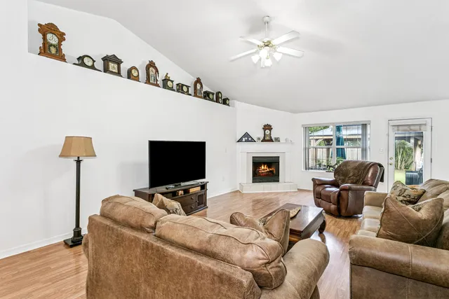 a living room with furniture a flat screen tv and a fireplace