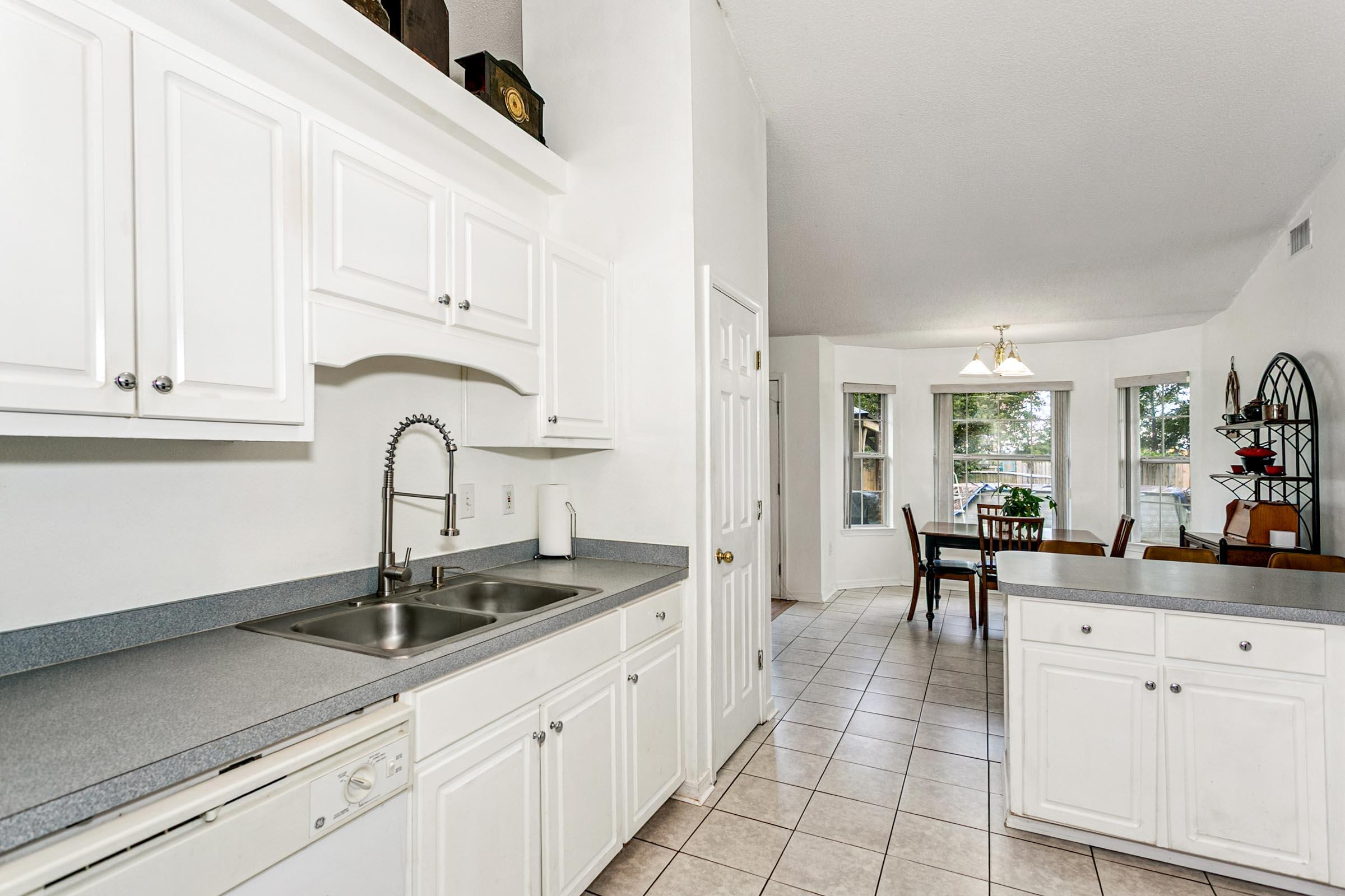 2246 Titanium Drive Crestview, FL 32536 - Photo 9 of 38 a kitchen with white cabinets a sink and appliances