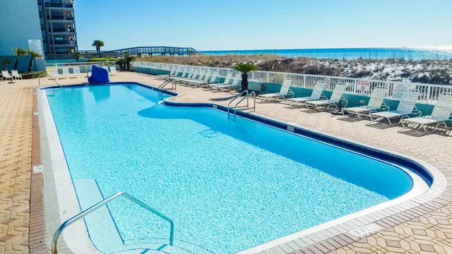 a view of swimming pool with outdoor seating and ocean view