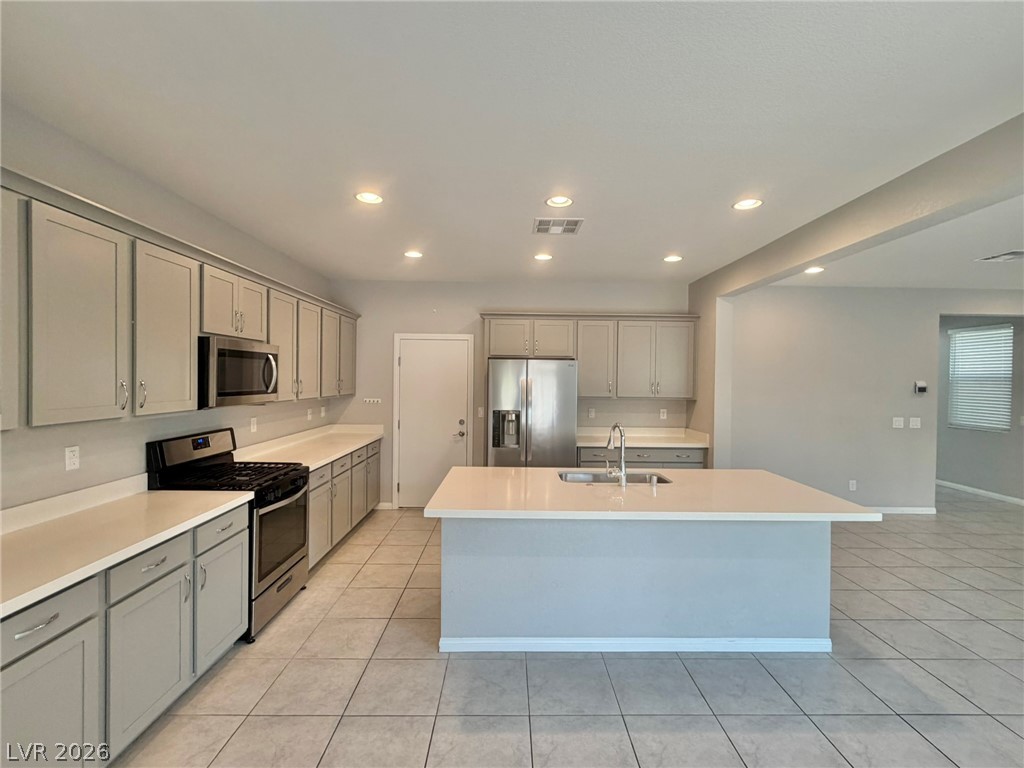 9953 Tucket Point Court Las Vegas, NV 89178 - Photo 9 of 22 Culinary delights await in this modern kitchen featuring a central island and abundant cabinet space.