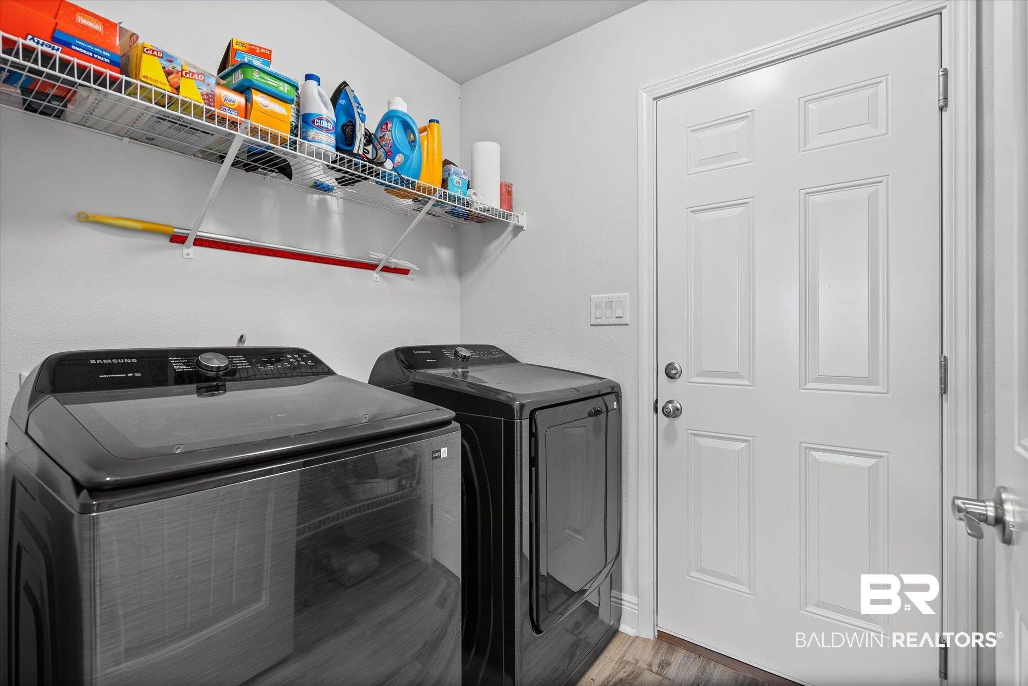 22420 Respite Lane Foley, AL 36535 - Photo 19 of 35 Dedicated laundry area featuring wood-finish flooring, a white paneled door, and a wire storage shelf