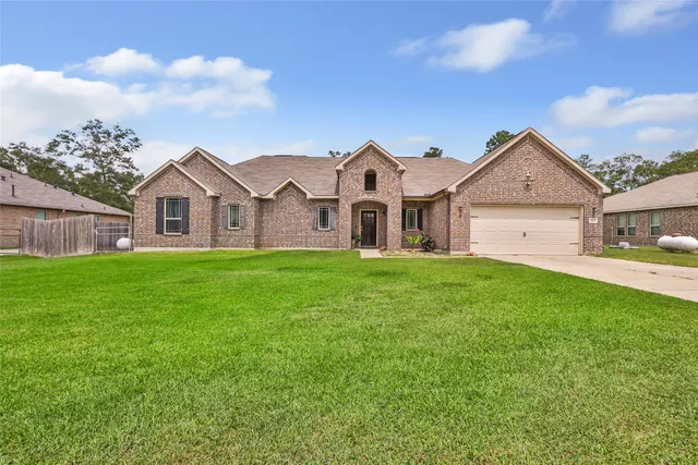 a view of a big house with a big yard and large trees