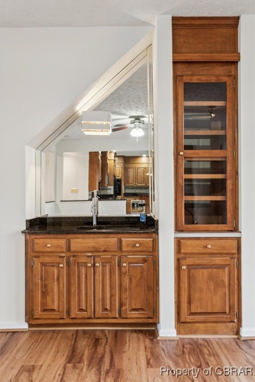 1318 Showalter Road Yorktown, VA 23692 - Photo 11 of 47 Bar with dark stone countertops, ceiling fan, sink, and light hardwood / wood-style floors