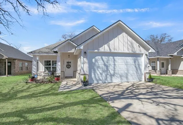 a front view of a house with a yard outdoor seating and garage