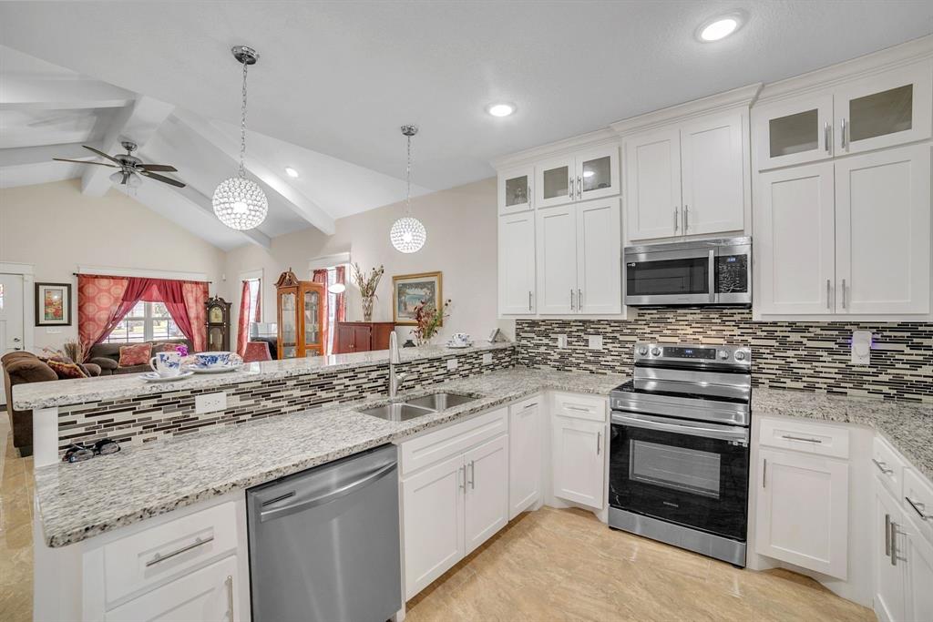 1207 South Lenox Street Tyler, TX 75701 - Photo 13 of 27 a kitchen with stainless steel appliances granite countertop a sink and stove top oven