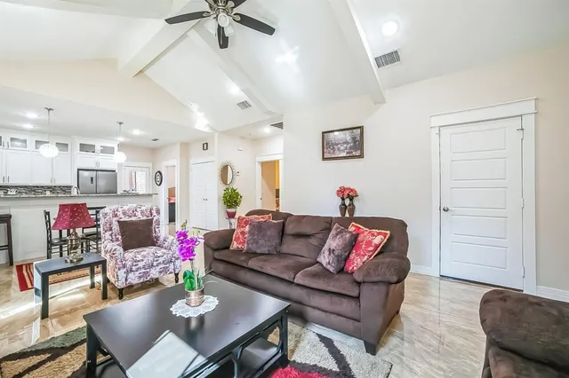a living room with furniture and kitchen view