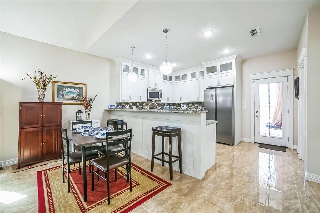 1207 South Lenox Street Tyler, TX 75701 - Photo 10 of 27 a kitchen with stainless steel appliances kitchen island granite countertop a refrigerator and microwave