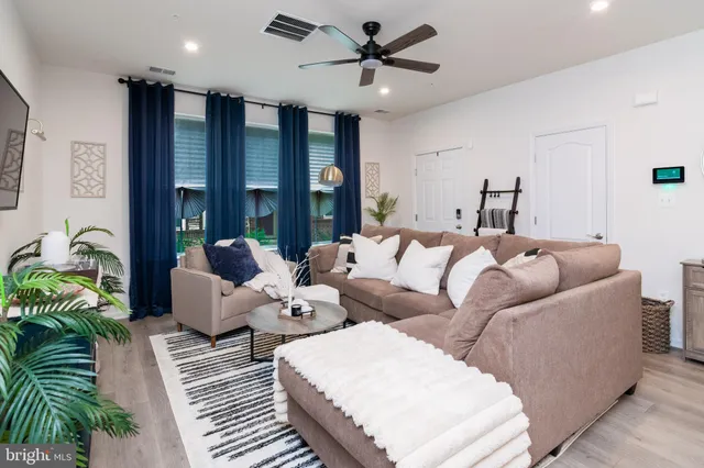 a living room with furniture ceiling fan and a window