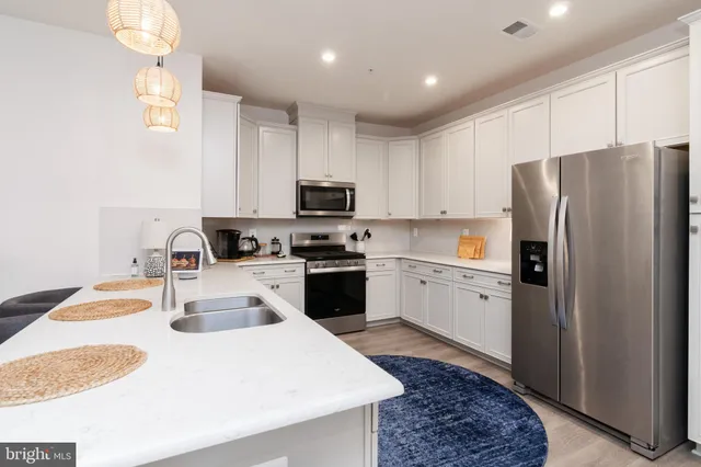 a kitchen with a refrigerator sink and white cabinets