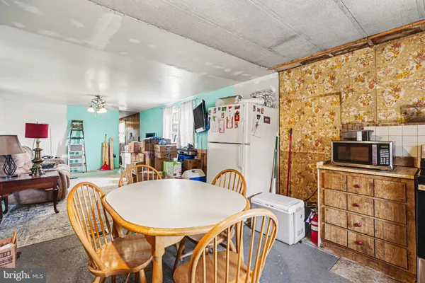 a living room with furniture a flat screen tv and kitchen view
