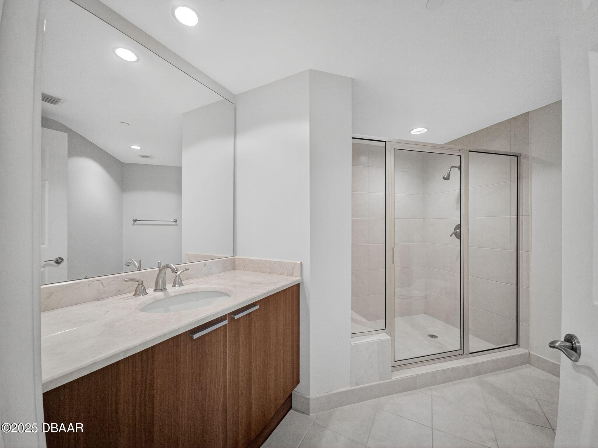 231 Riverside Drive, Unit 2409 Holly Hill, FL 32117 - Photo 21 of 24 a bathroom with a shower sink vanity and mirror