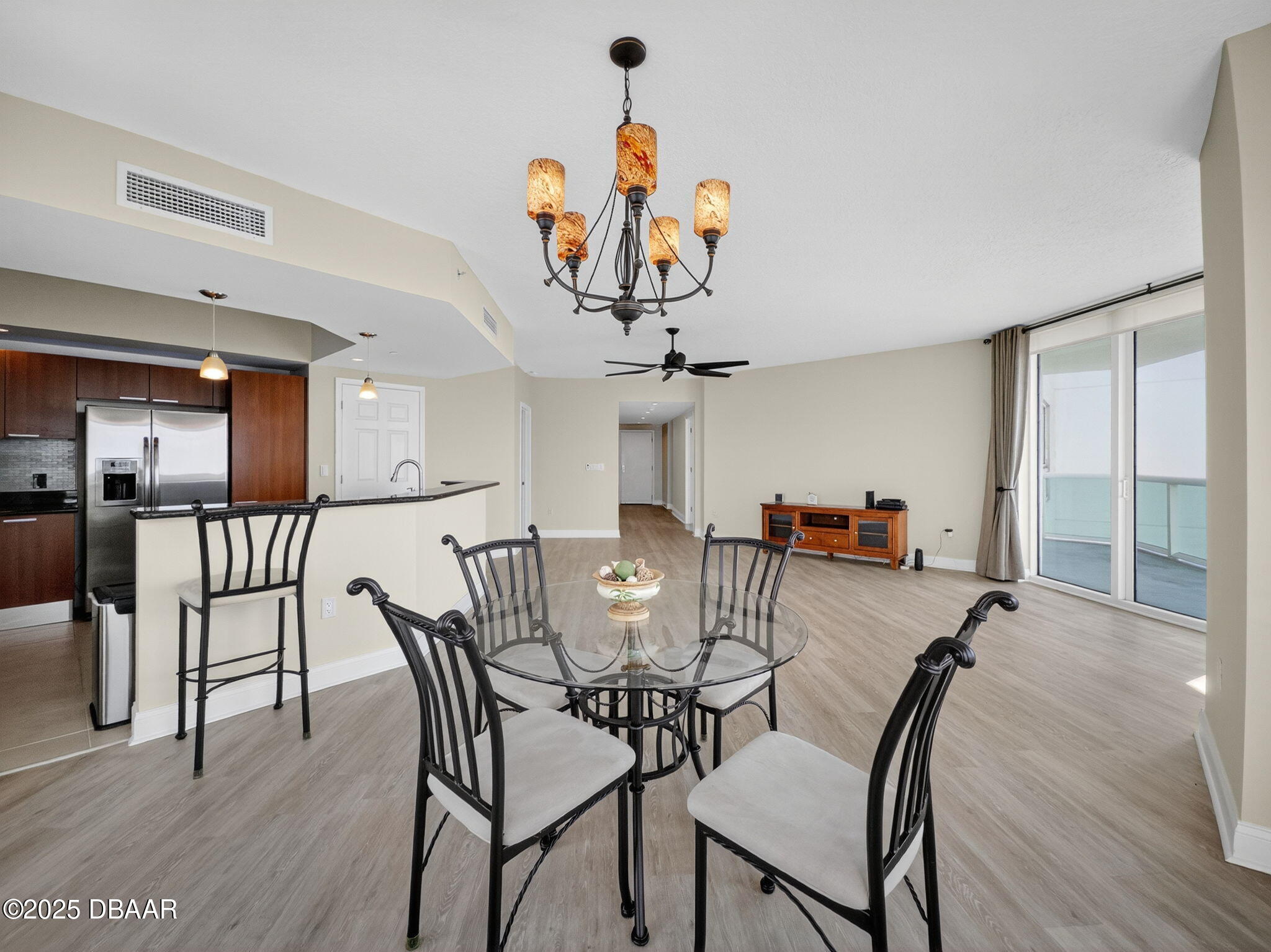 231 Riverside Drive, Unit 2409 Holly Hill, FL 32117 - Photo 8 of 24 a view of a dining room and livingroom with furniture wooden floor a chandelier