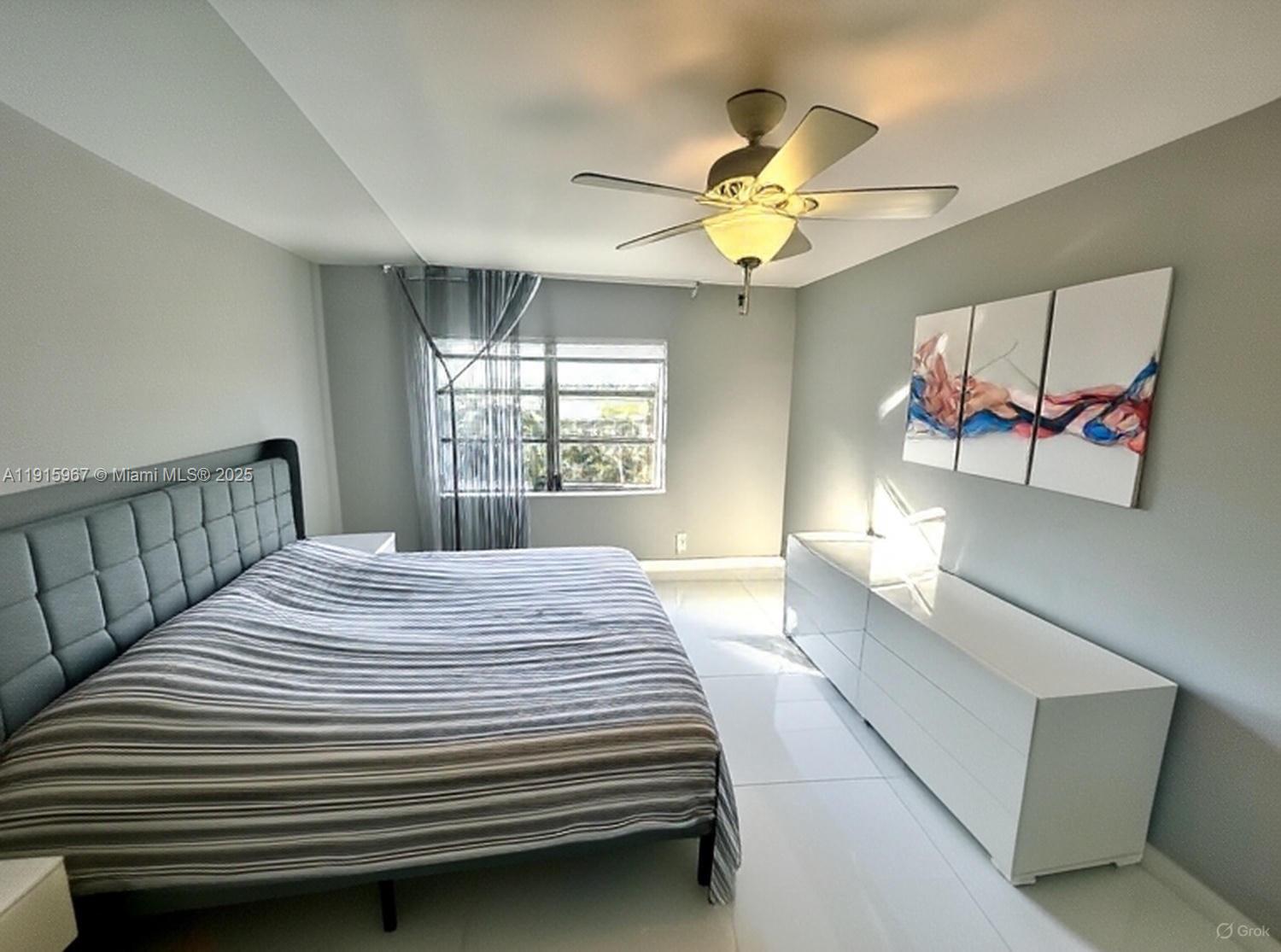 200 Diplomat Parkway, Unit 721 Hallandale Beach, FL 33009 - Photo 11 of 47 a bedroom with a bed and a chandelier