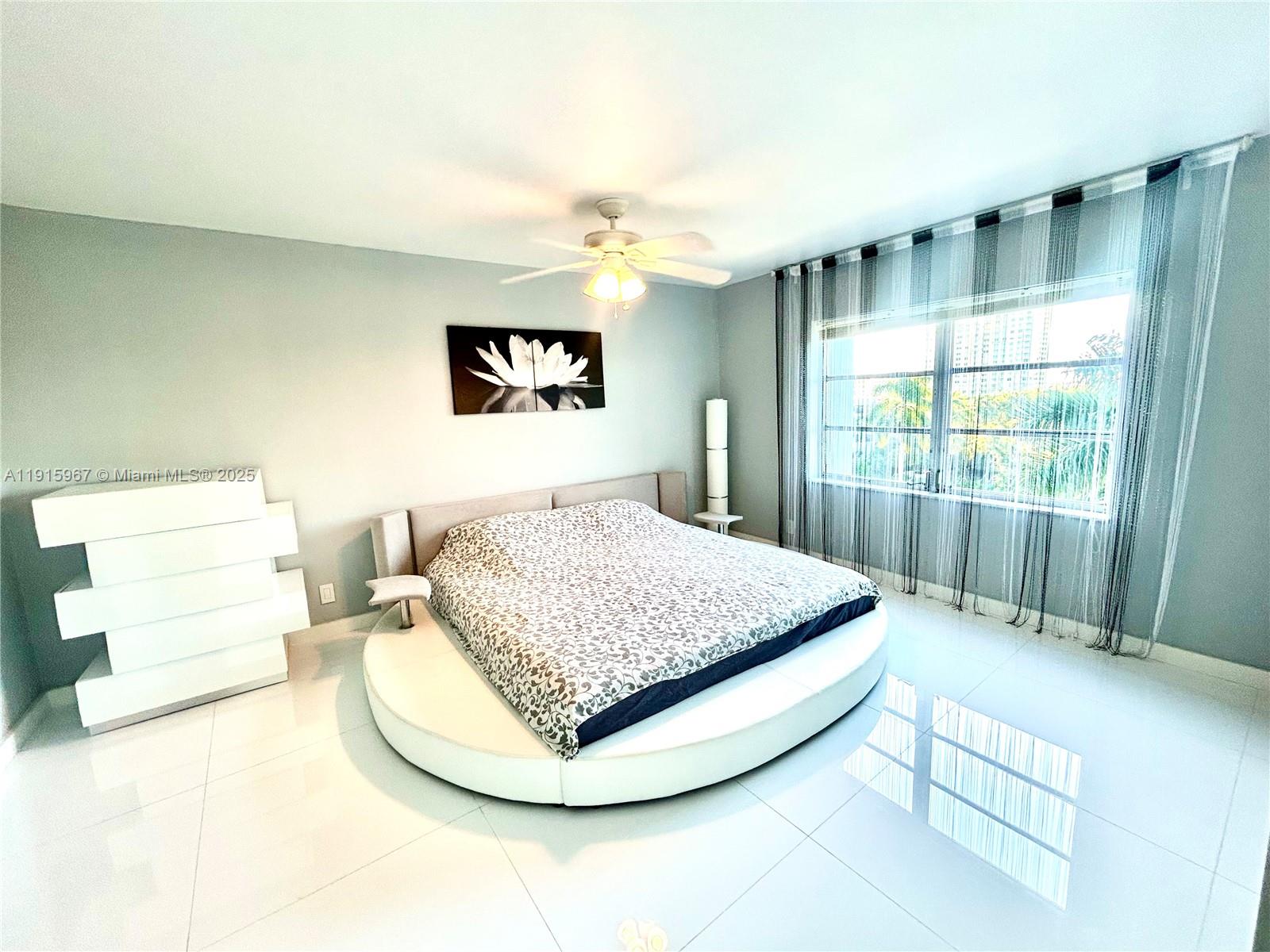 200 Diplomat Parkway, Unit 721 Hallandale Beach, FL 33009 - Photo 12 of 47 a bedroom with a bed and a large window