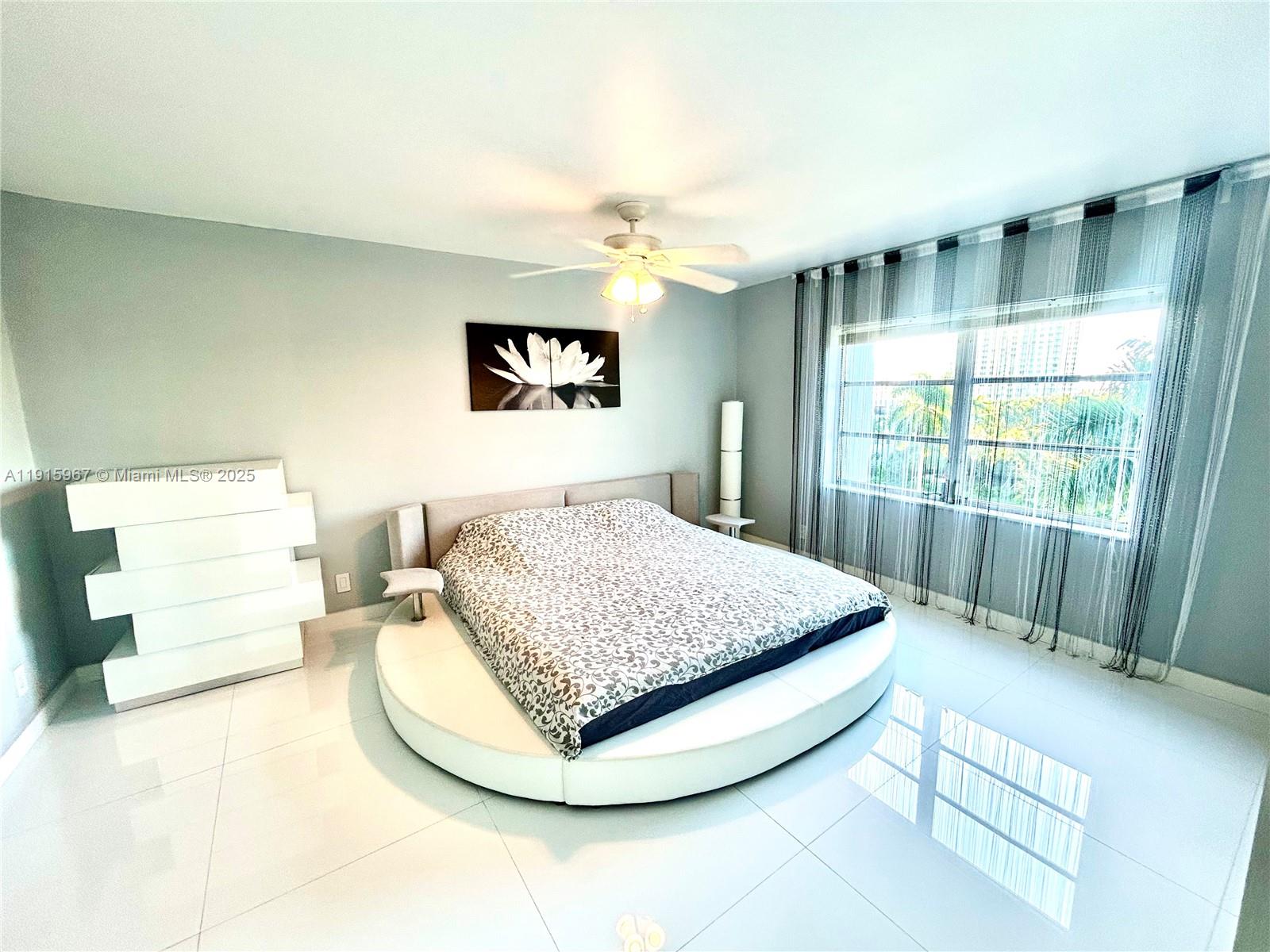 200 Diplomat Parkway, Unit 721 Hallandale Beach, FL 33009 - Photo 15 of 47 a bedroom with a bed and a large window