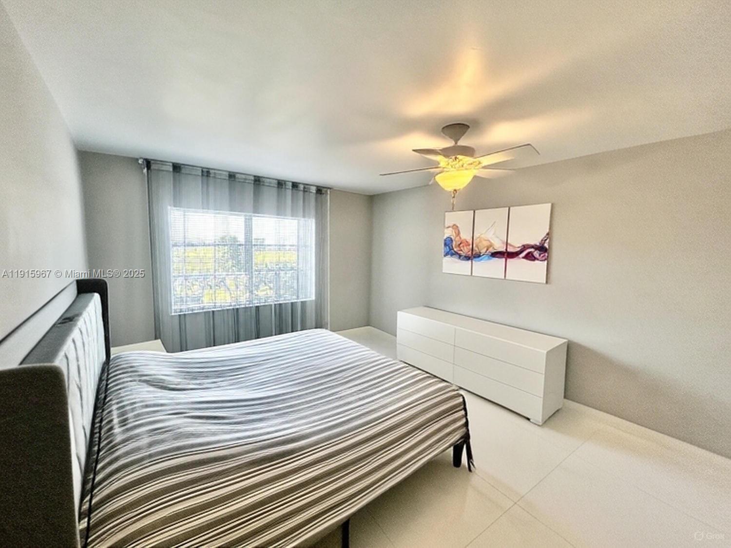 200 Diplomat Parkway, Unit 721 Hallandale Beach, FL 33009 - Photo 17 of 47 a bedroom with a bed and a chandelier