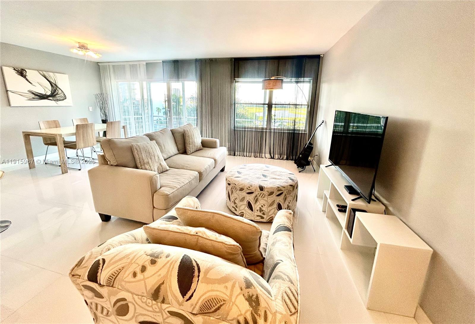 200 Diplomat Parkway, Unit 721 Hallandale Beach, FL 33009 - Photo 2 of 47 a living room with furniture and a flat screen tv