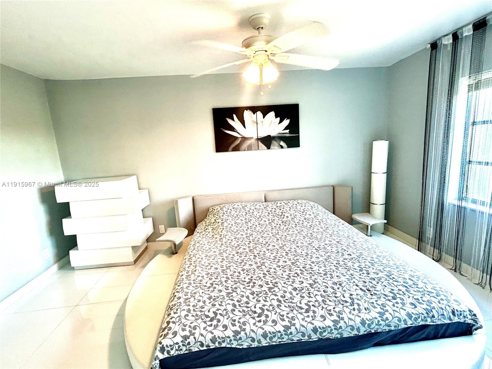 200 Diplomat Parkway, Unit 721 Hallandale Beach, FL 33009 - Photo 23 of 47 a bedroom with a large bed and a chandelier