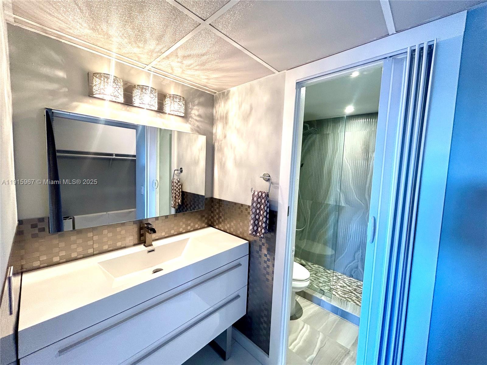 200 Diplomat Parkway, Unit 721 Hallandale Beach, FL 33009 - Photo 26 of 47 a bathroom with a sink and a mirror