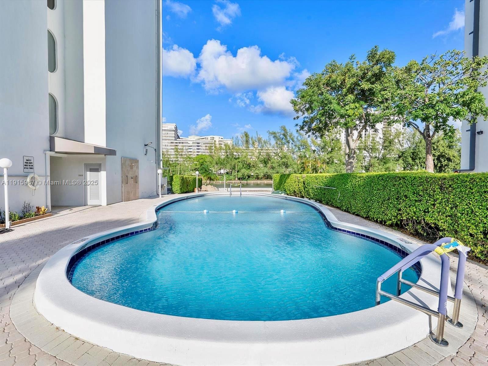 200 Diplomat Parkway, Unit 721 Hallandale Beach, FL 33009 - Photo 32 of 47 a view of a swimming pool with a yard