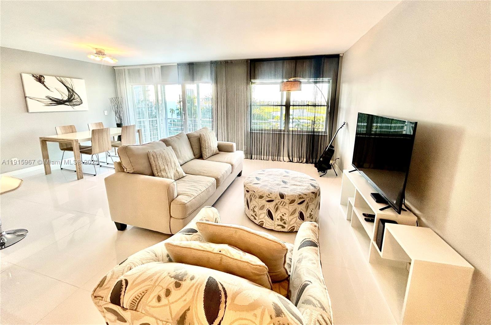 200 Diplomat Parkway, Unit 721 Hallandale Beach, FL 33009 - Photo 6 of 47 a living room with furniture window and a flat screen tv