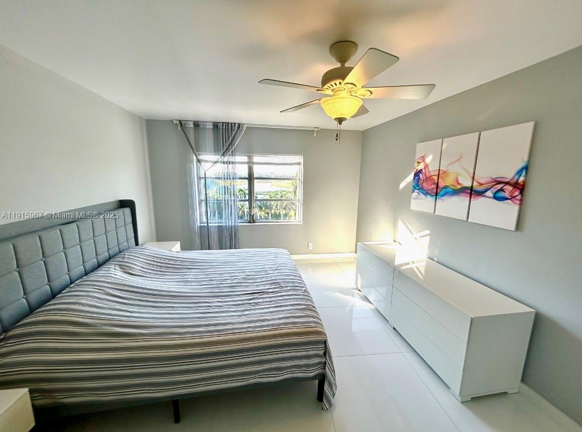 200 Diplomat Parkway, Unit 721 Hallandale Beach, FL 33009 - Photo 9 of 47 a bedroom with a bed and a chandelier