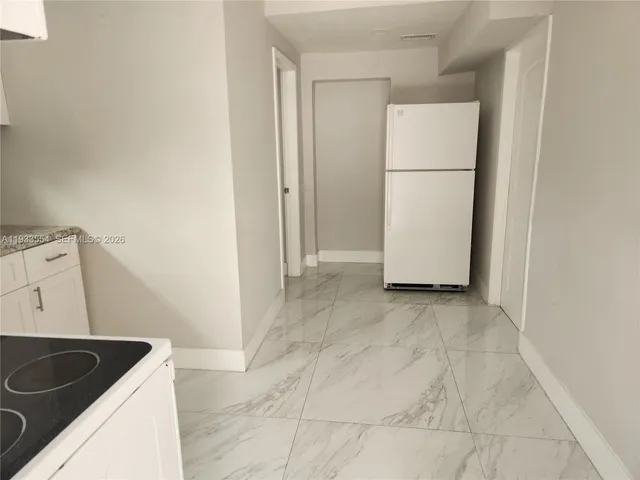 a kitchen with granite countertop white cabinets and white appliances