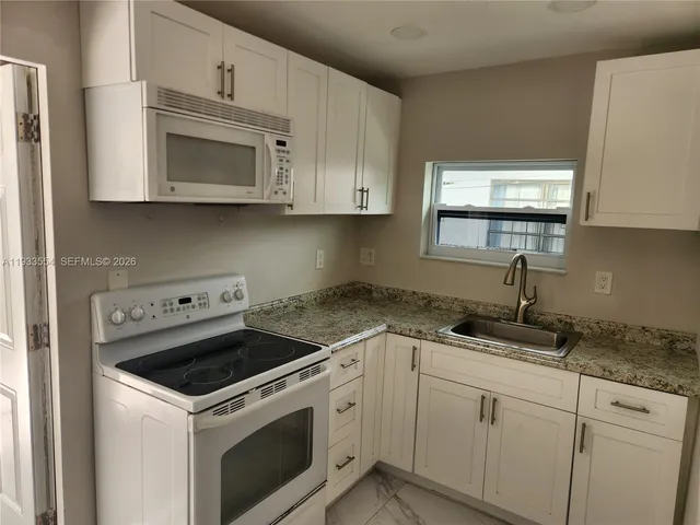 a kitchen with cabinets appliances and a window