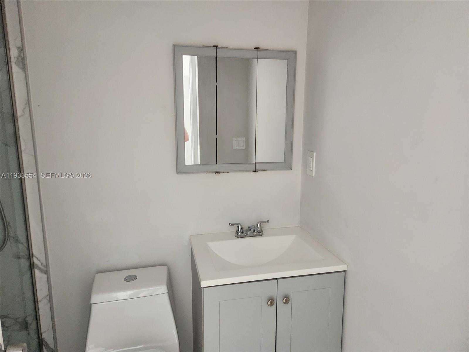 342 East 46th Street, Unit 2 Hialeah, FL 33013 - Photo 6 of 15 a bathroom with a sink a toilet and a mirror