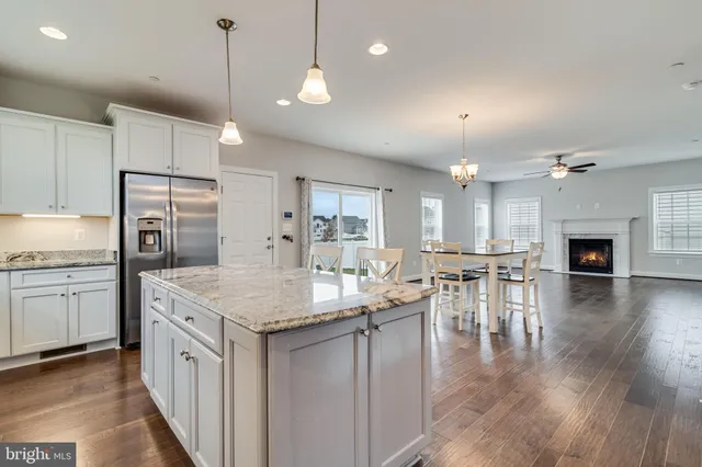 a view of a livingroom with furniture wooden floor window and a kitchen view