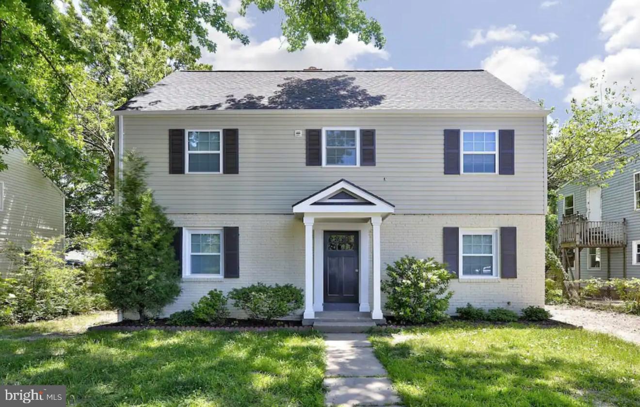 a front view of a house with a yard and potted plants