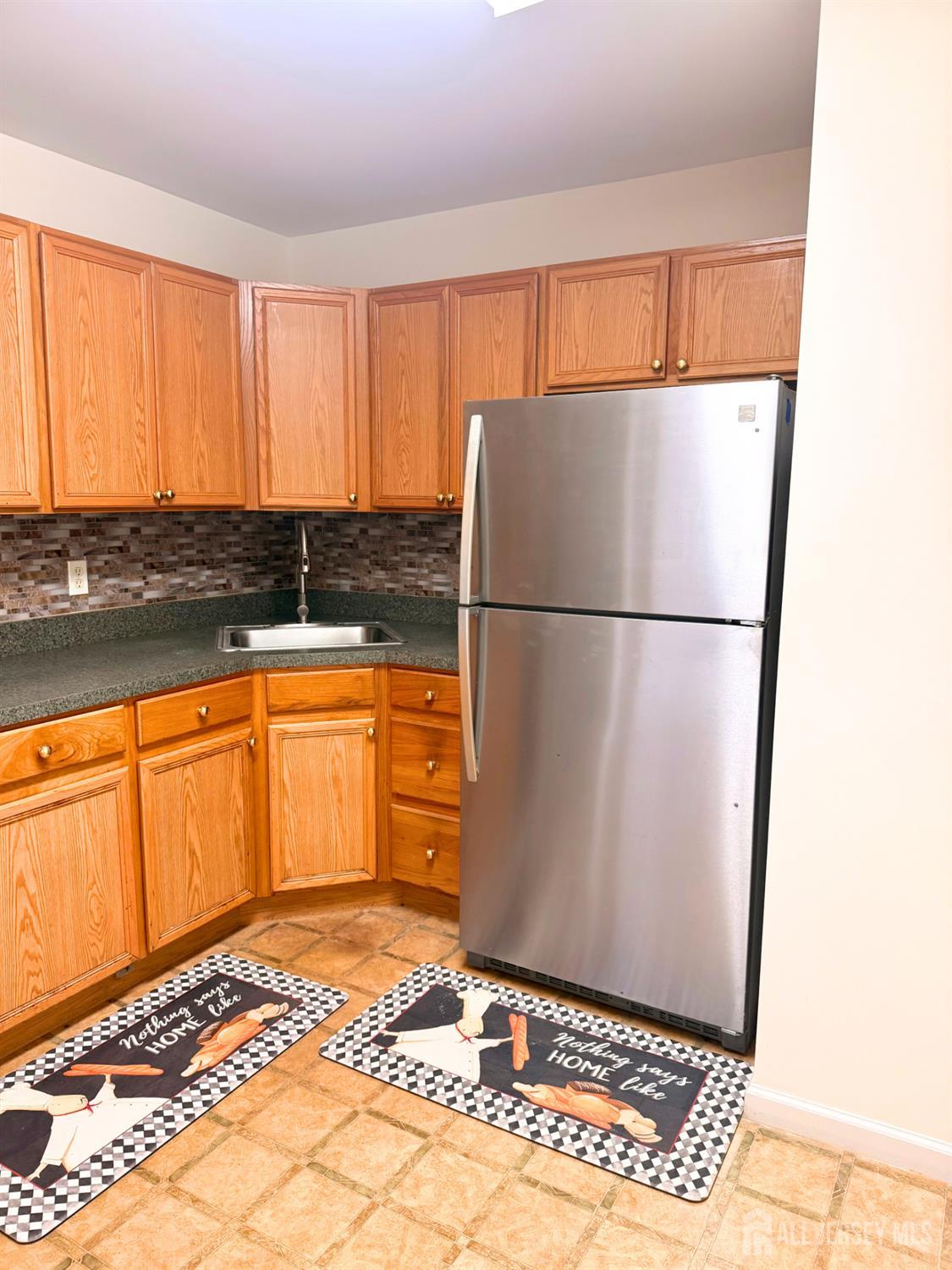 413 College Drive Edison, NJ 08817 - Photo 11 of 20 a kitchen with a refrigerator a stove top oven and cabinets