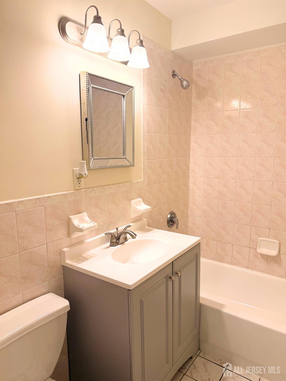 413 College Drive Edison, NJ 08817 - Photo 16 of 20 a bathroom with a sink vanity mirror and toilet