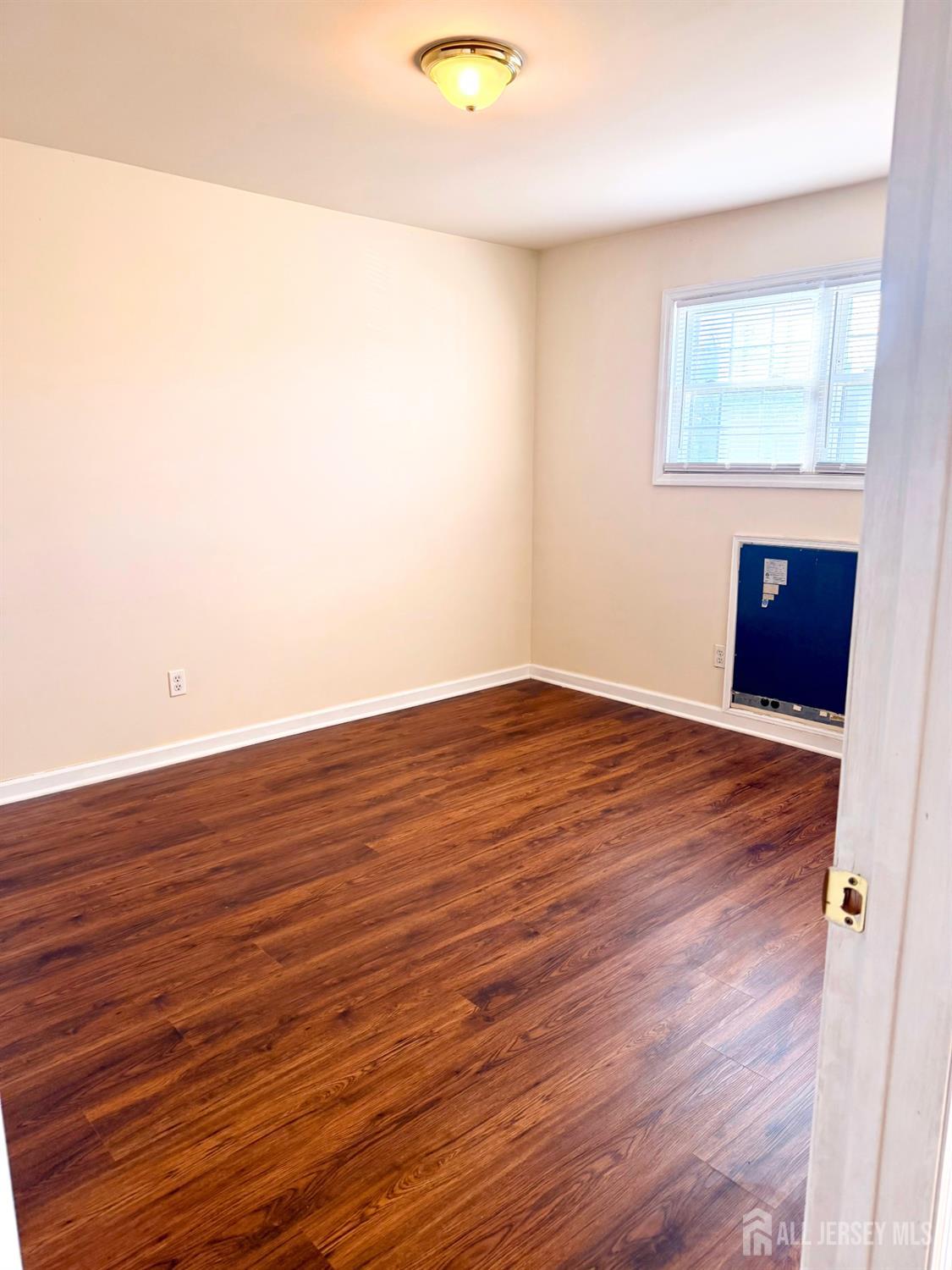 413 College Drive Edison, NJ 08817 - Photo 7 of 20 an empty room with wooden floor and windows