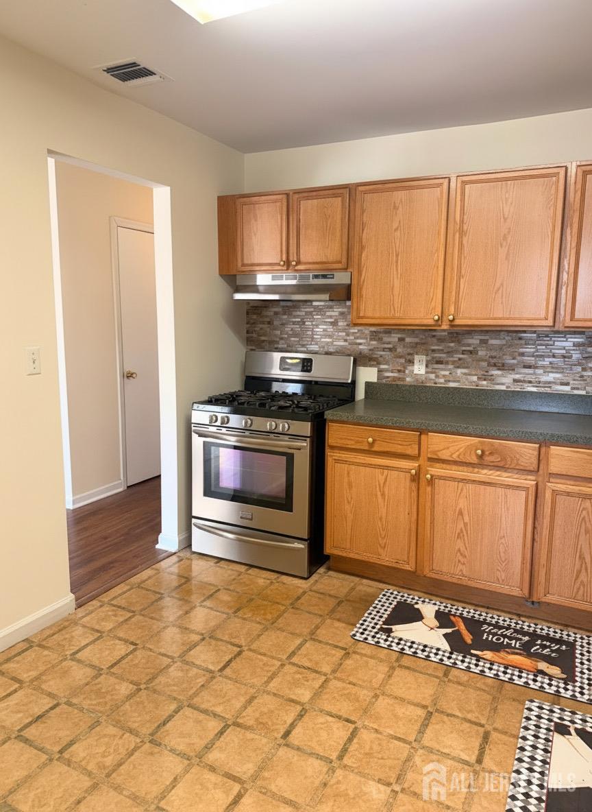 413 College Drive Edison, NJ 08817 - Photo 10 of 20 a kitchen with a stove a sink and a microwave