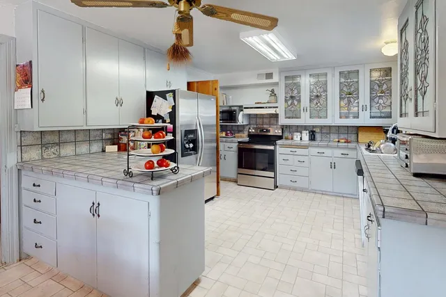 a kitchen with stainless steel appliances kitchen island granite countertop a refrigerator and stove