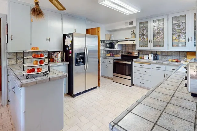 a kitchen with stainless steel appliances a refrigerator sink and cabinets