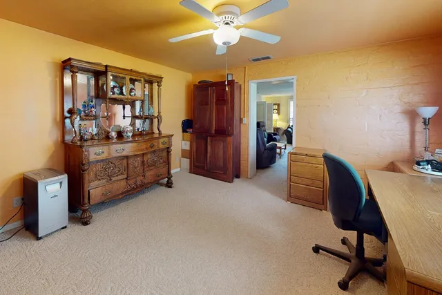 a view of a workspace with furniture and a window