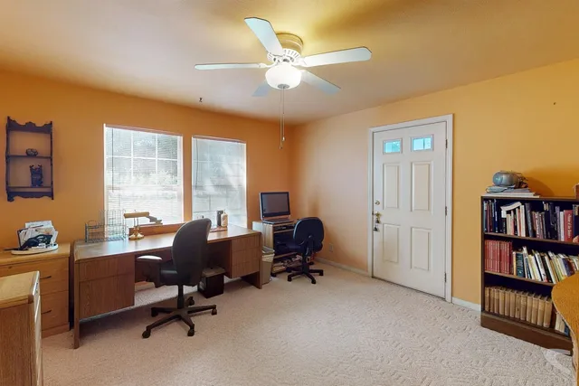 a view of a workspace with furniture and a bookshelf
