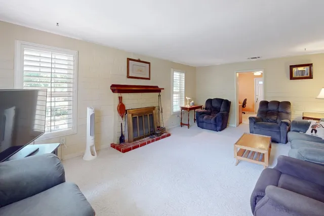 a living room with furniture a window and a flat screen tv