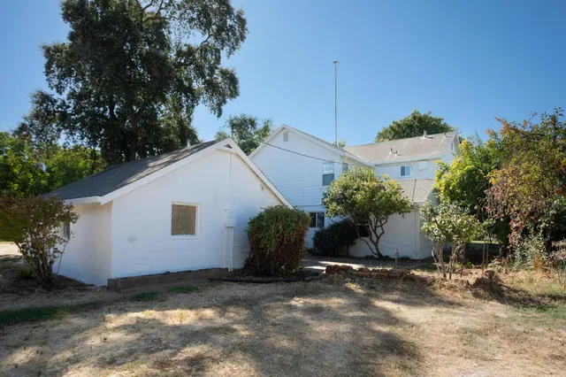 a view of a house with backyard and trees