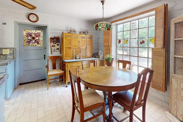 a dining room with furniture a chandelier and window