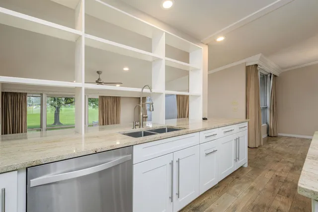 a kitchen with granite countertop a sink and white cabinets