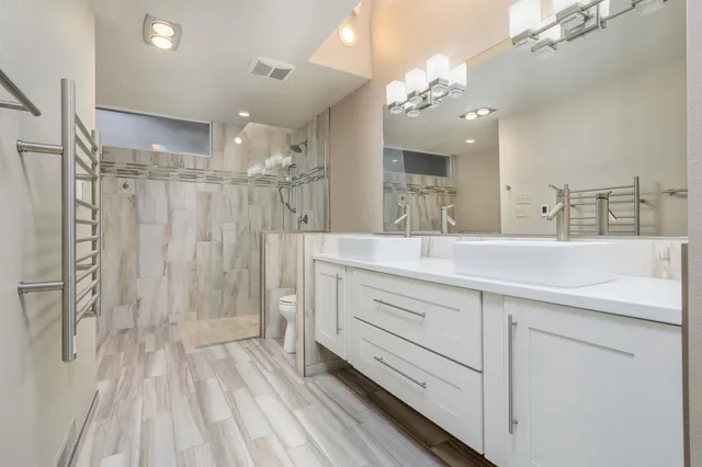 a bathroom with a double vanity sink mirror and shower