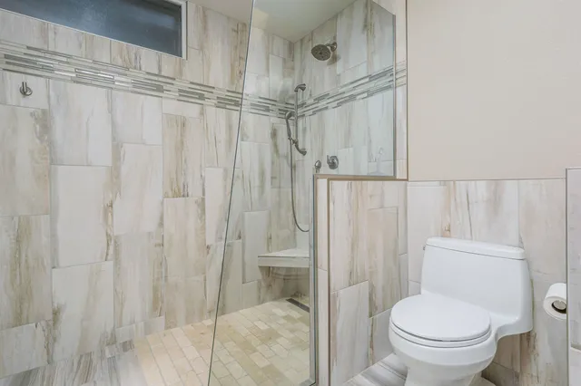a bathroom with a toilet and a shower
