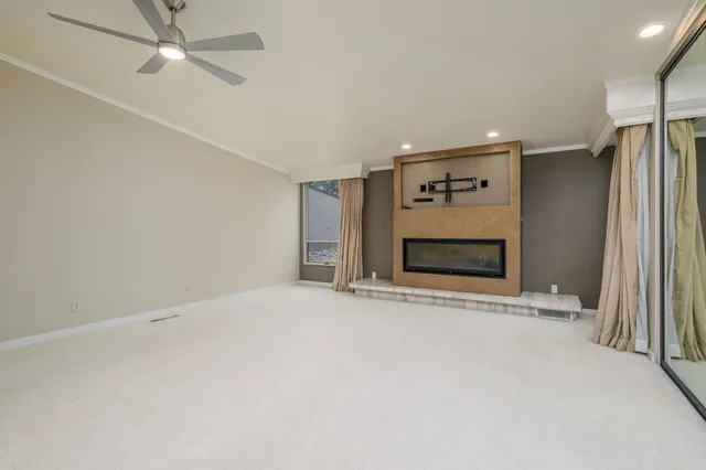 an empty room with closet and a ceiling fan