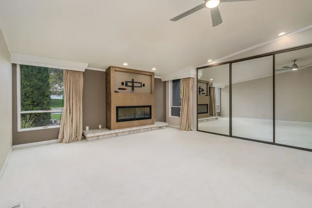 a view of an empty room with a fireplace and a window