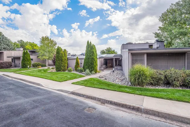 a view of a house with a big yard plants and large trees